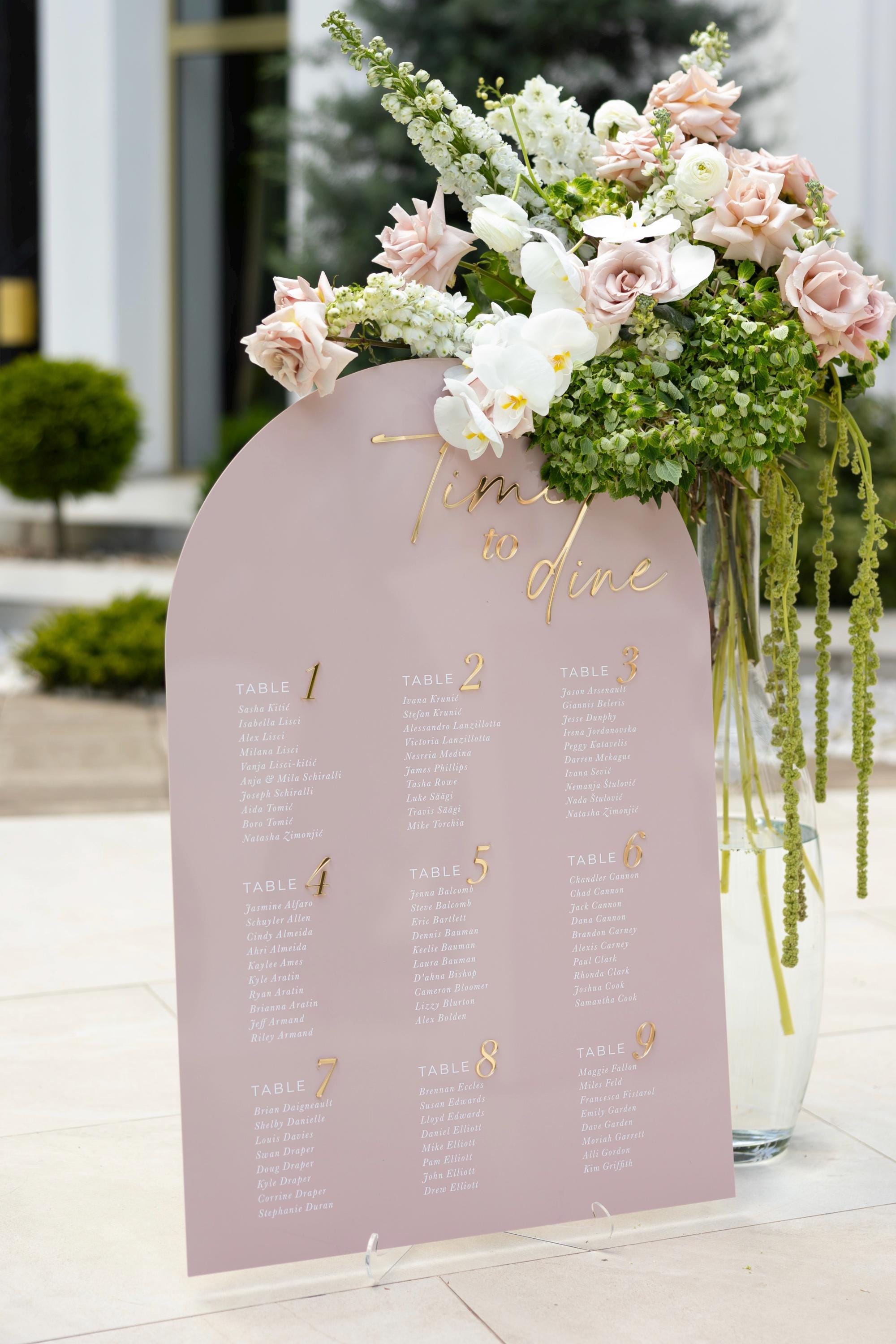 Romantic pink and gold seating chart displaying guest list
