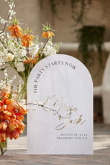 Arched white acrylic wedding welcome sign with personalized names and date
