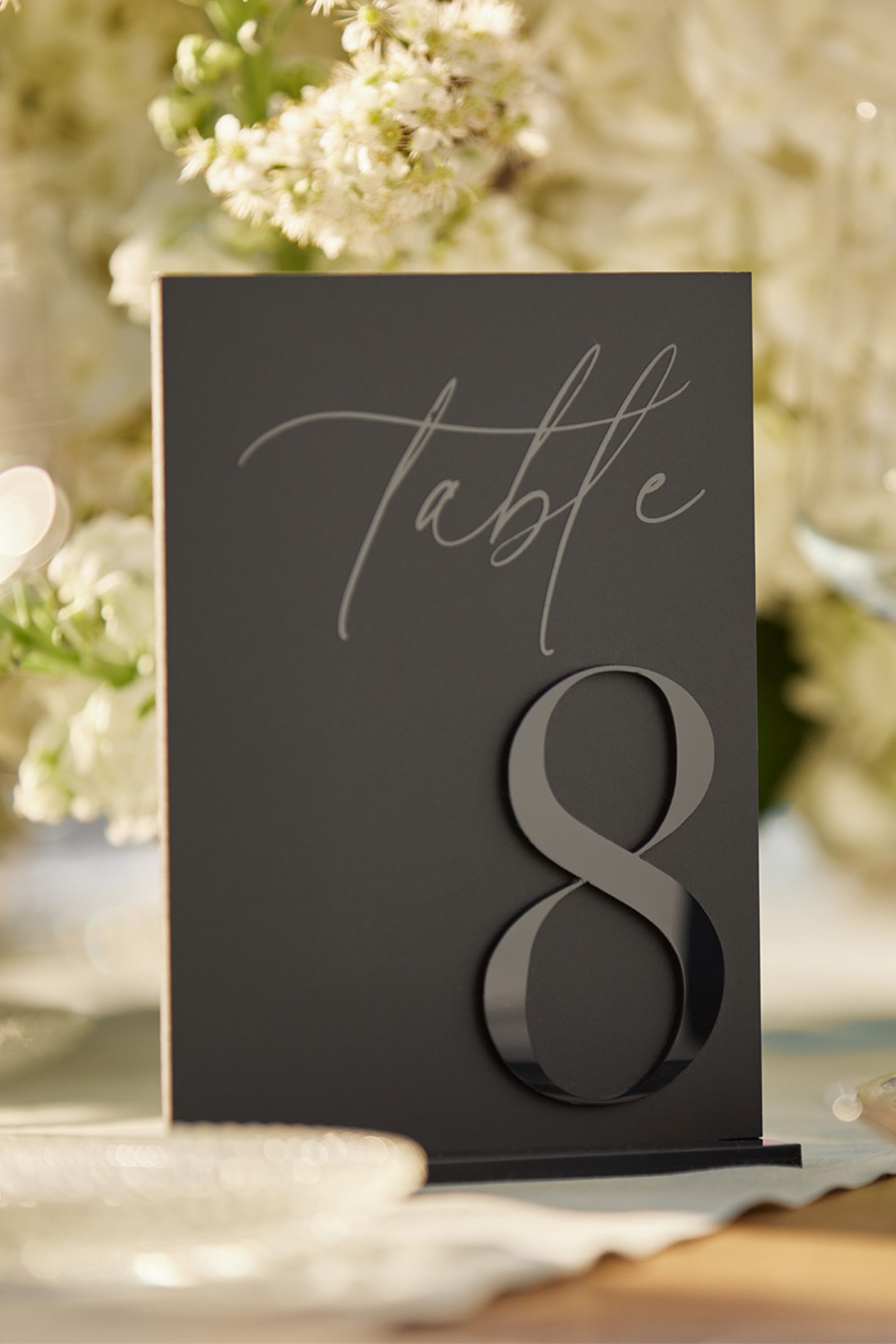 Detail of black on black 3D acrylic lettering on matte background.