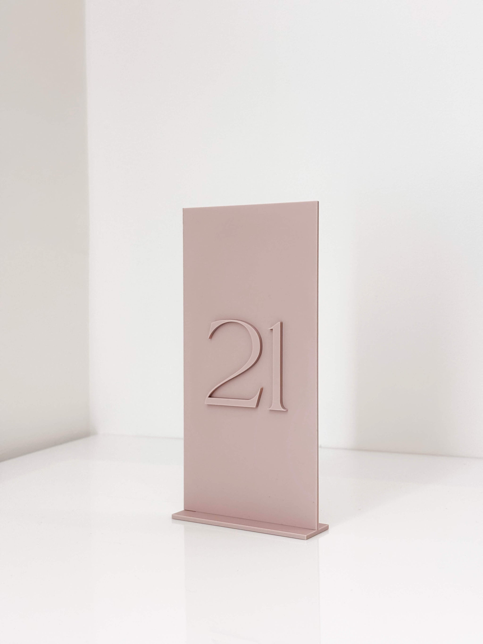 Modern romantic wedding table decor featuring dusty pink acrylic signage.