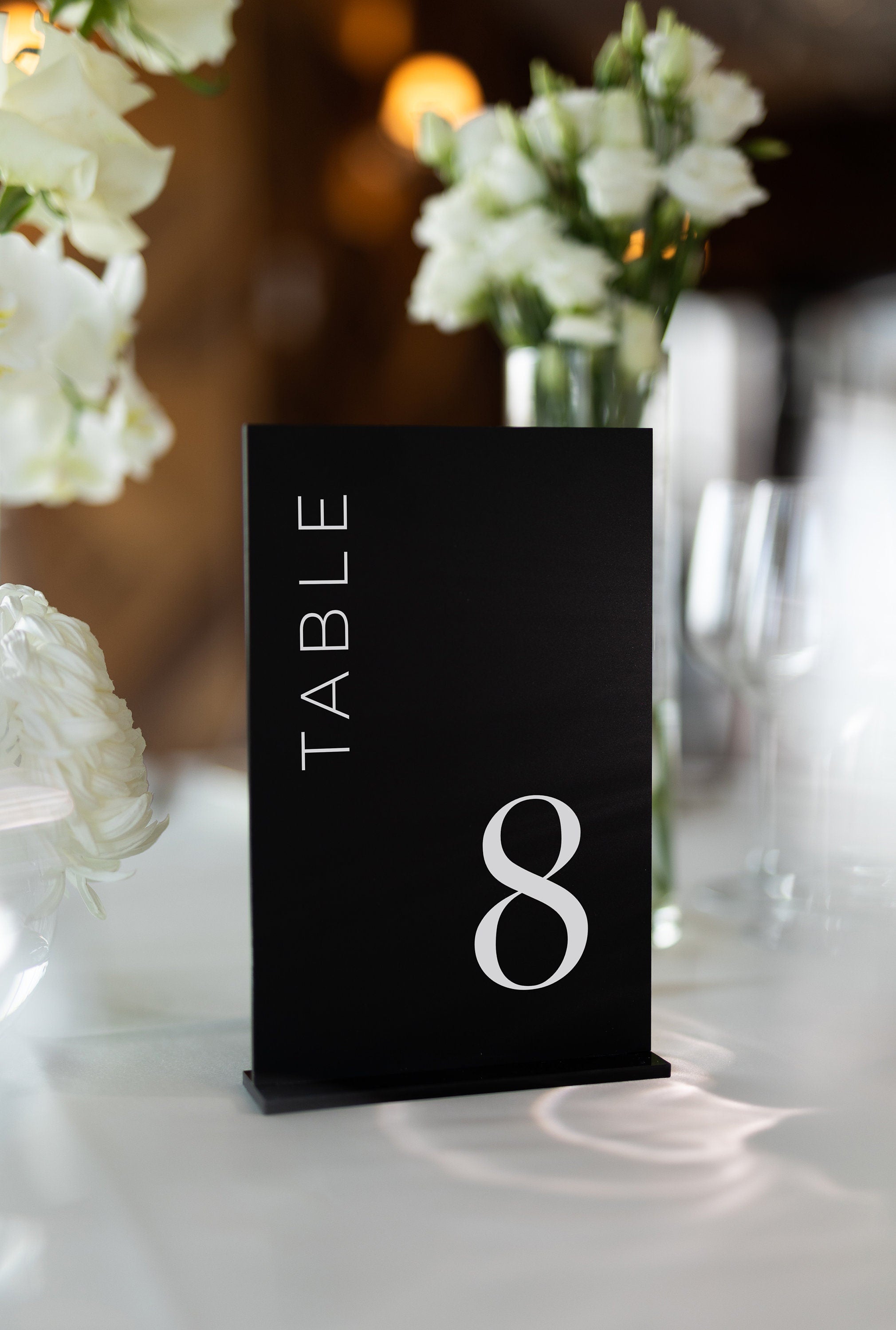 Matte black acrylic table number with elegant vertical text layout