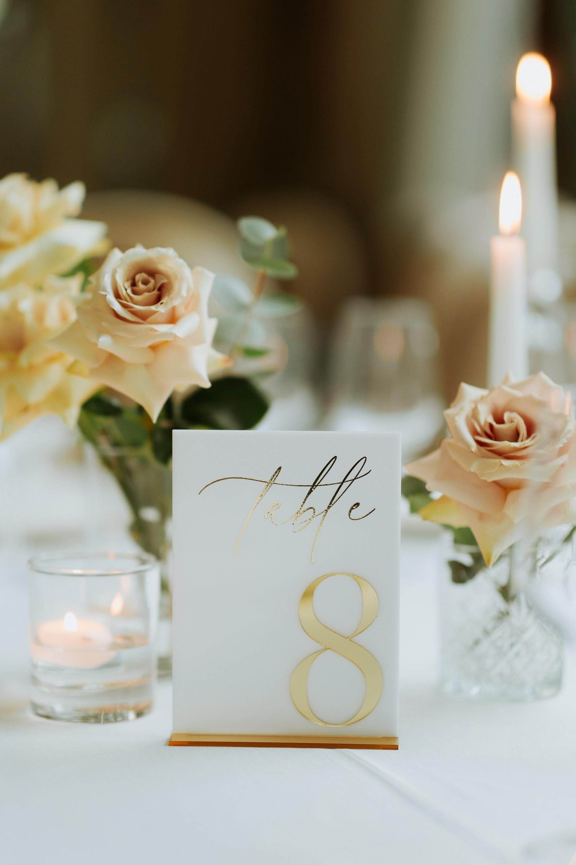 Elegant white and gold wedding table sign with matching stand