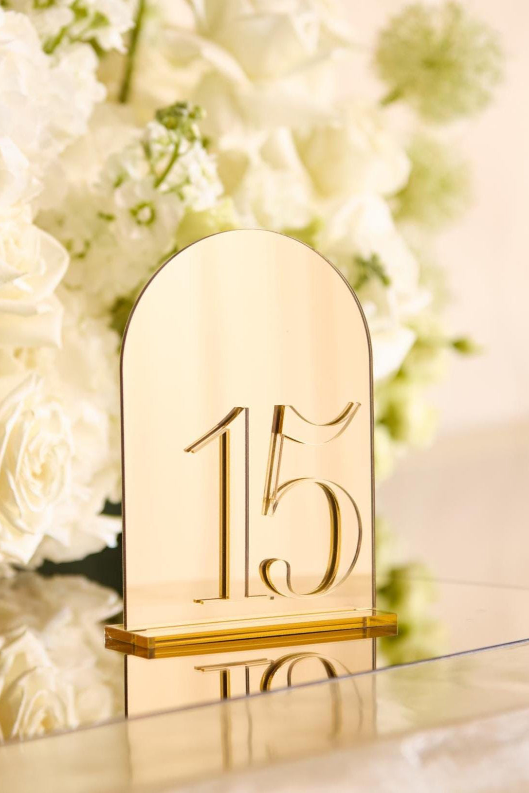 Arched gold mirror acrylic table number with reflective surface and base
