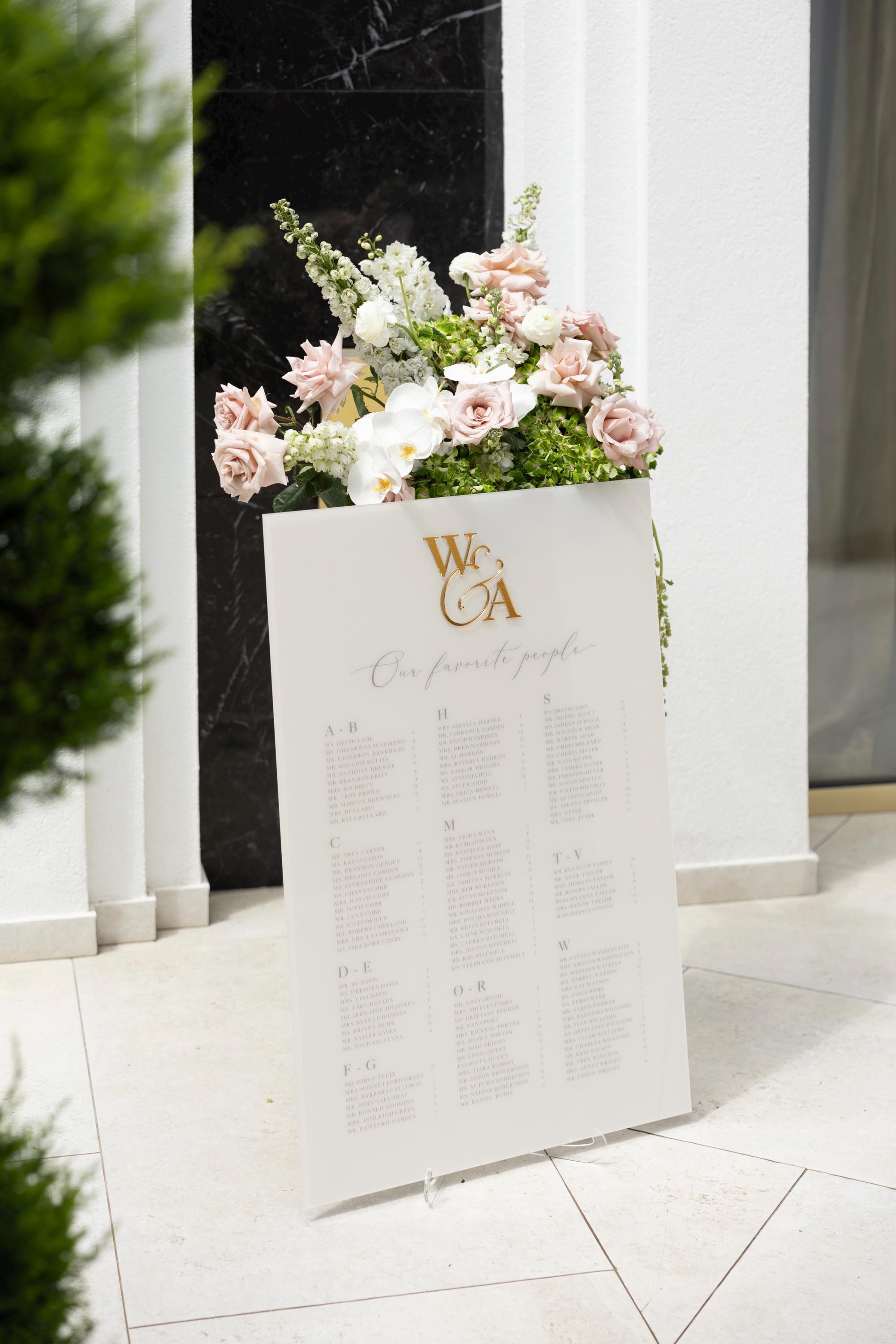 Wedding seating plan beige acrylic with alphabetical guest names and gold accents
