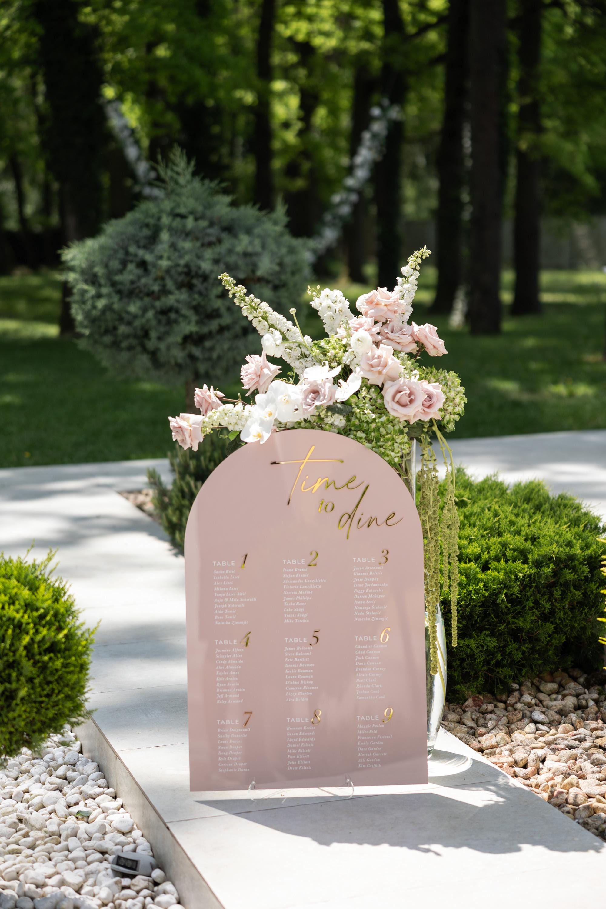 Arched pink acrylic table assignment sign with 3D gold mirror lettering
