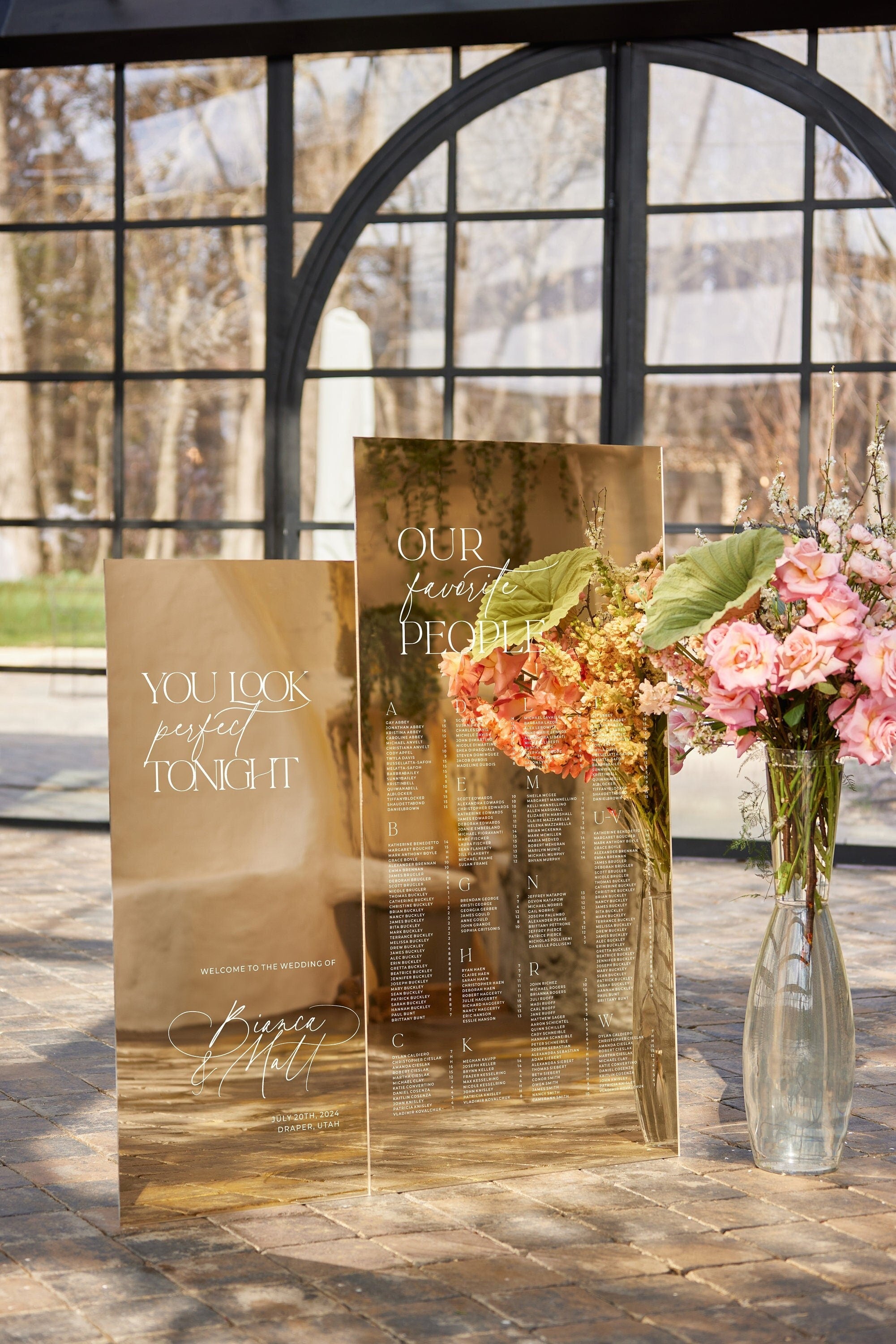 Our Favorite People seating plan and welcome sign in gold mirror acrylic at wedding ceremony entrance
