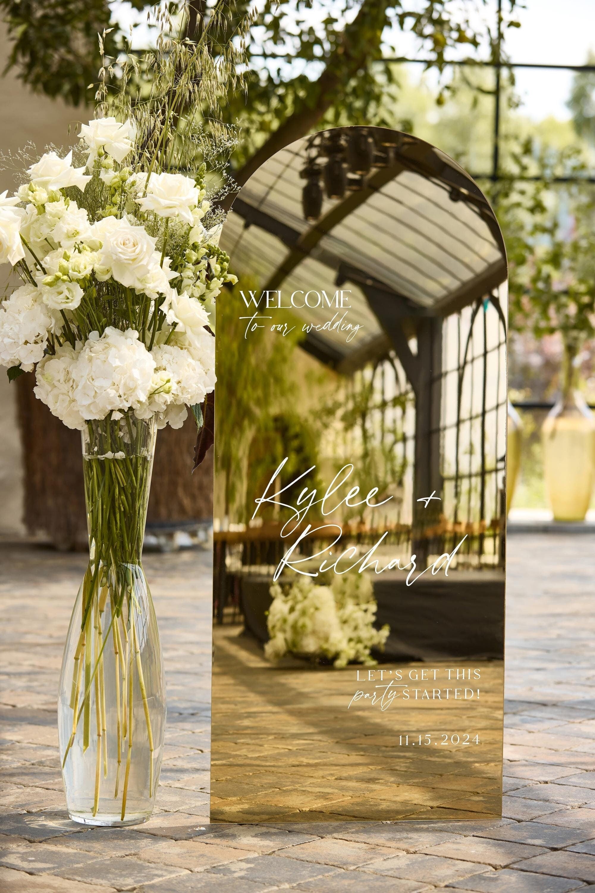 Chic modern wedding entrance decor with simple gold mirror arch sign on stand.