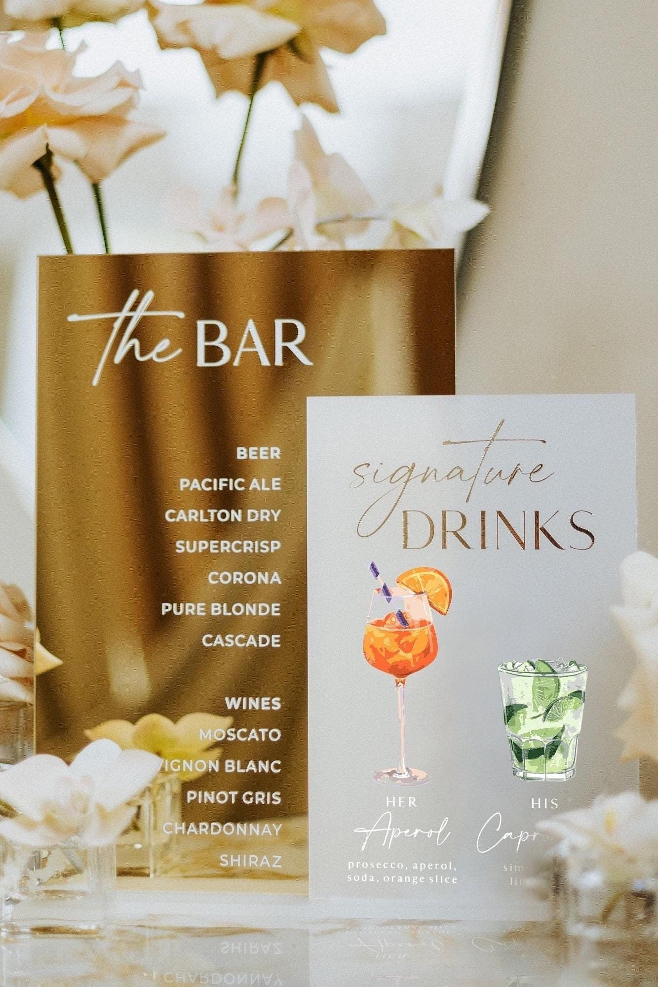 Gold mirror and frosted acrylic wedding bar signs displaying signature drinks
