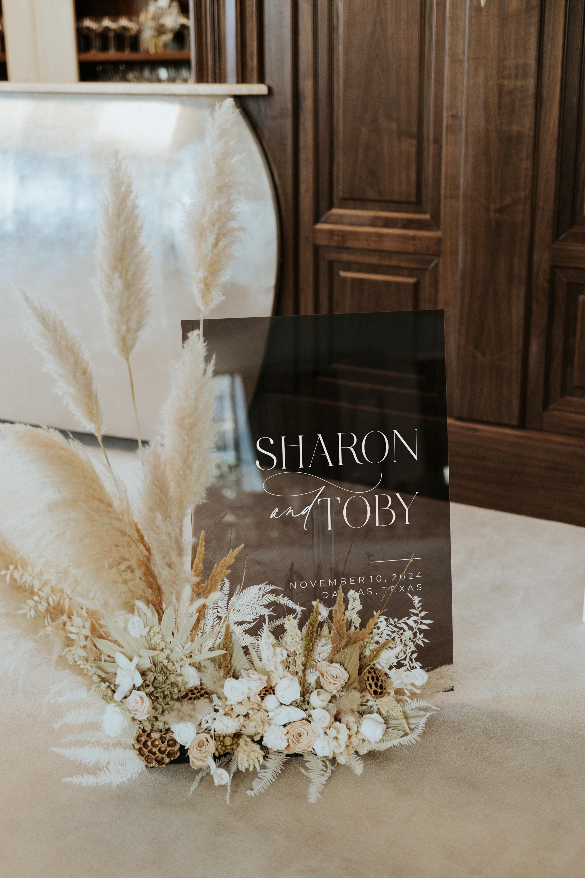 Translucent smoked grey acrylic sign with modern white calligraphy.