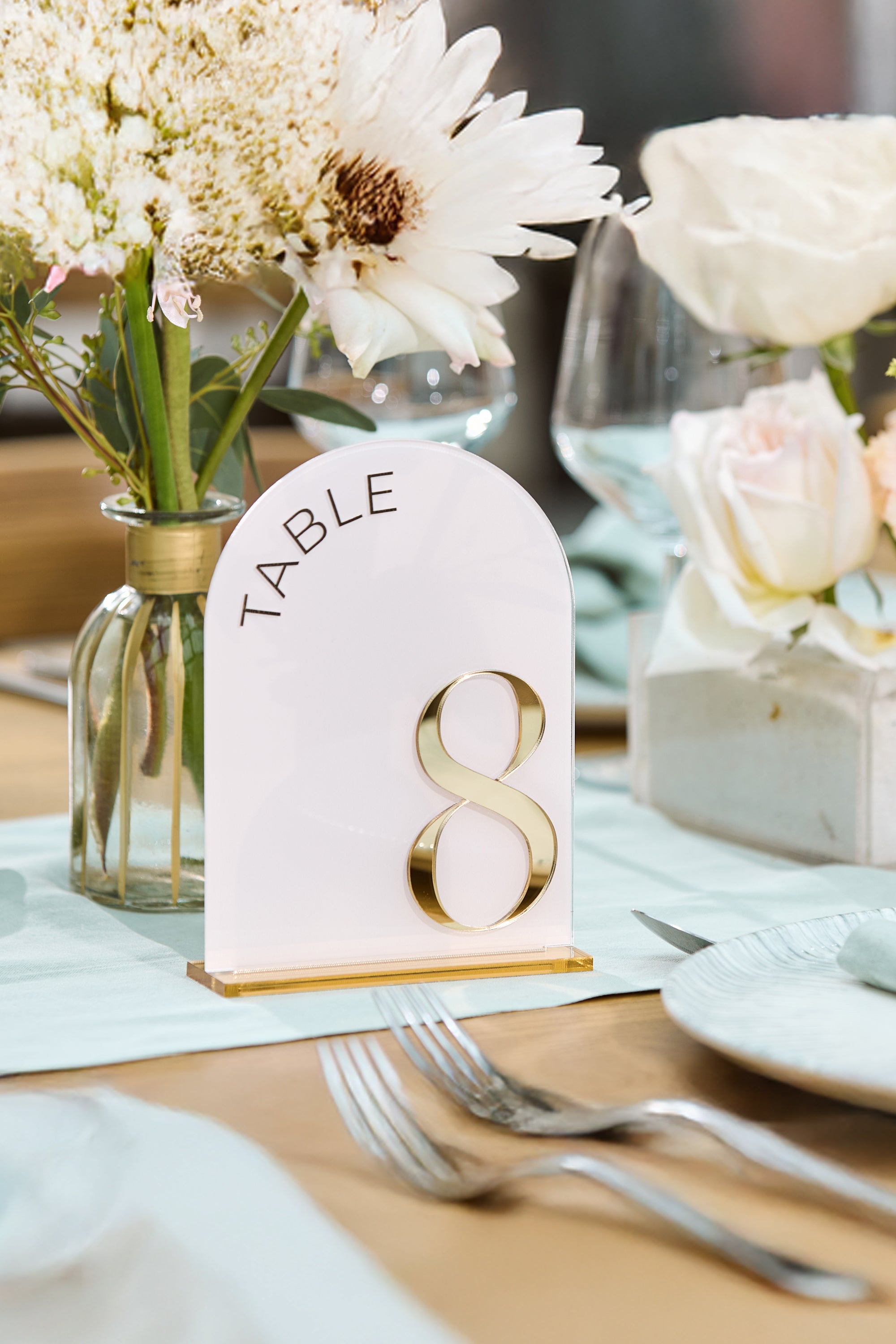  Close up of gold mirror number on blush pink acrylic background.