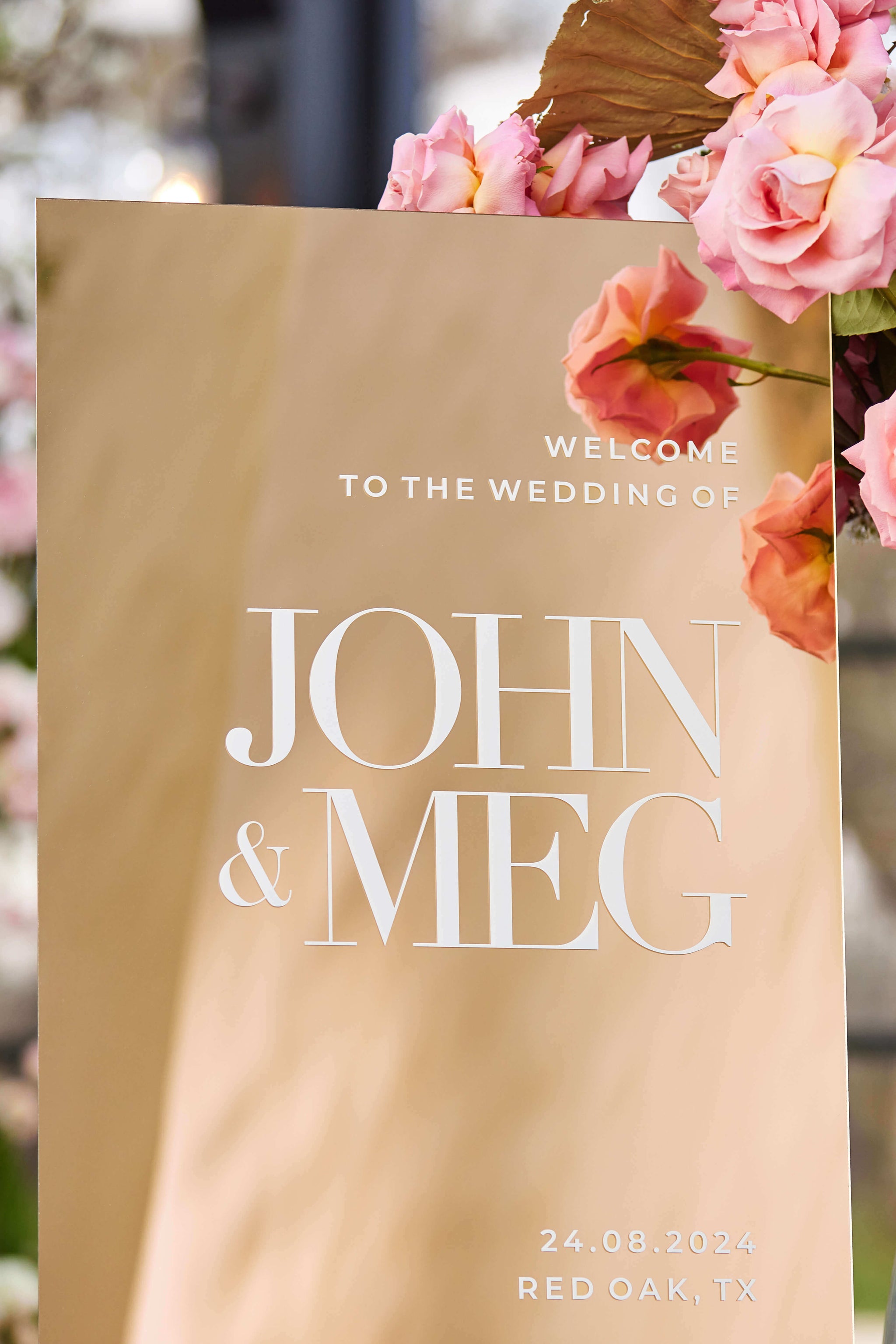 Close up detail of personalized names on a gold mirror surface.