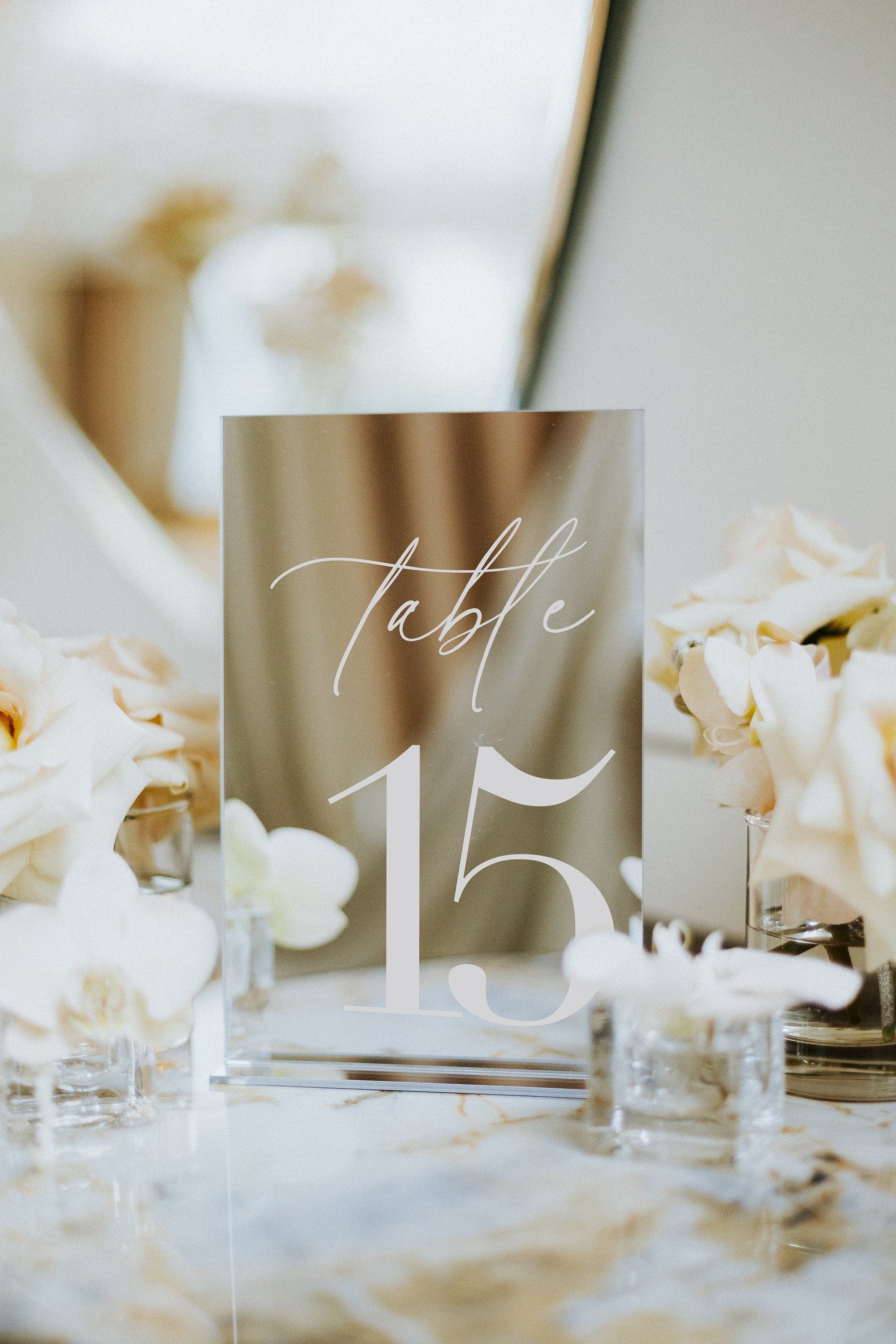 Silver mirror wedding table numbers displayed at elegant reception setting
