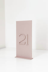 3D dusty pink acrylic wedding table number sign in 4x8 inch size standing on a table.