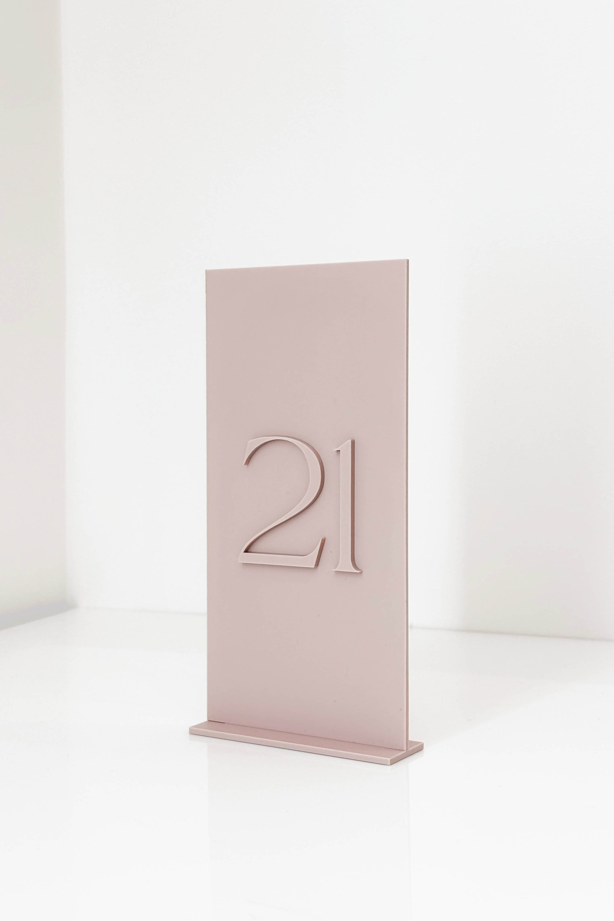 3D dusty pink acrylic wedding table number sign in 4x8 inch size standing on a table.