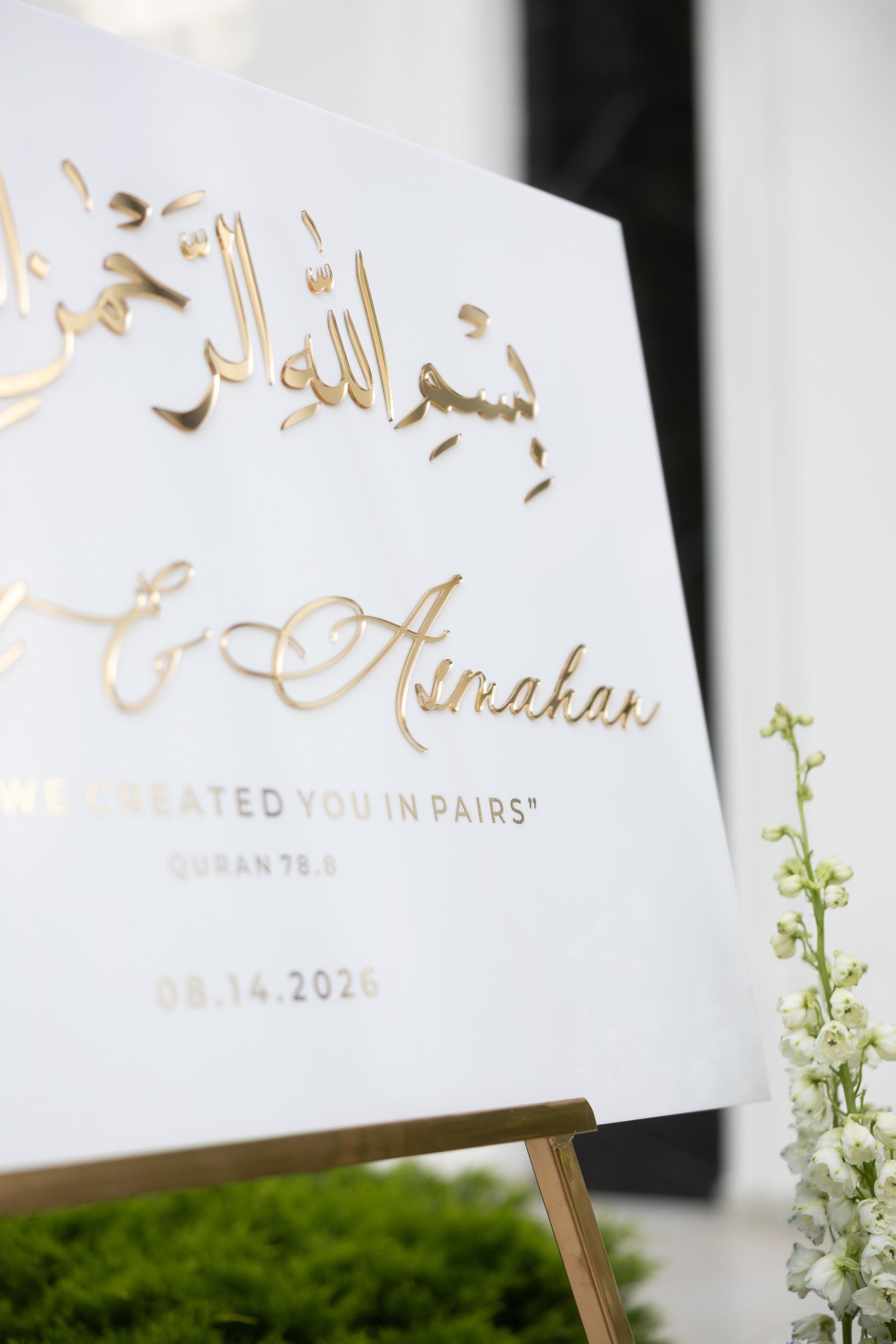 Close-up of 3D gold mirror Arabic calligraphy on white Nikkah welcome sign
