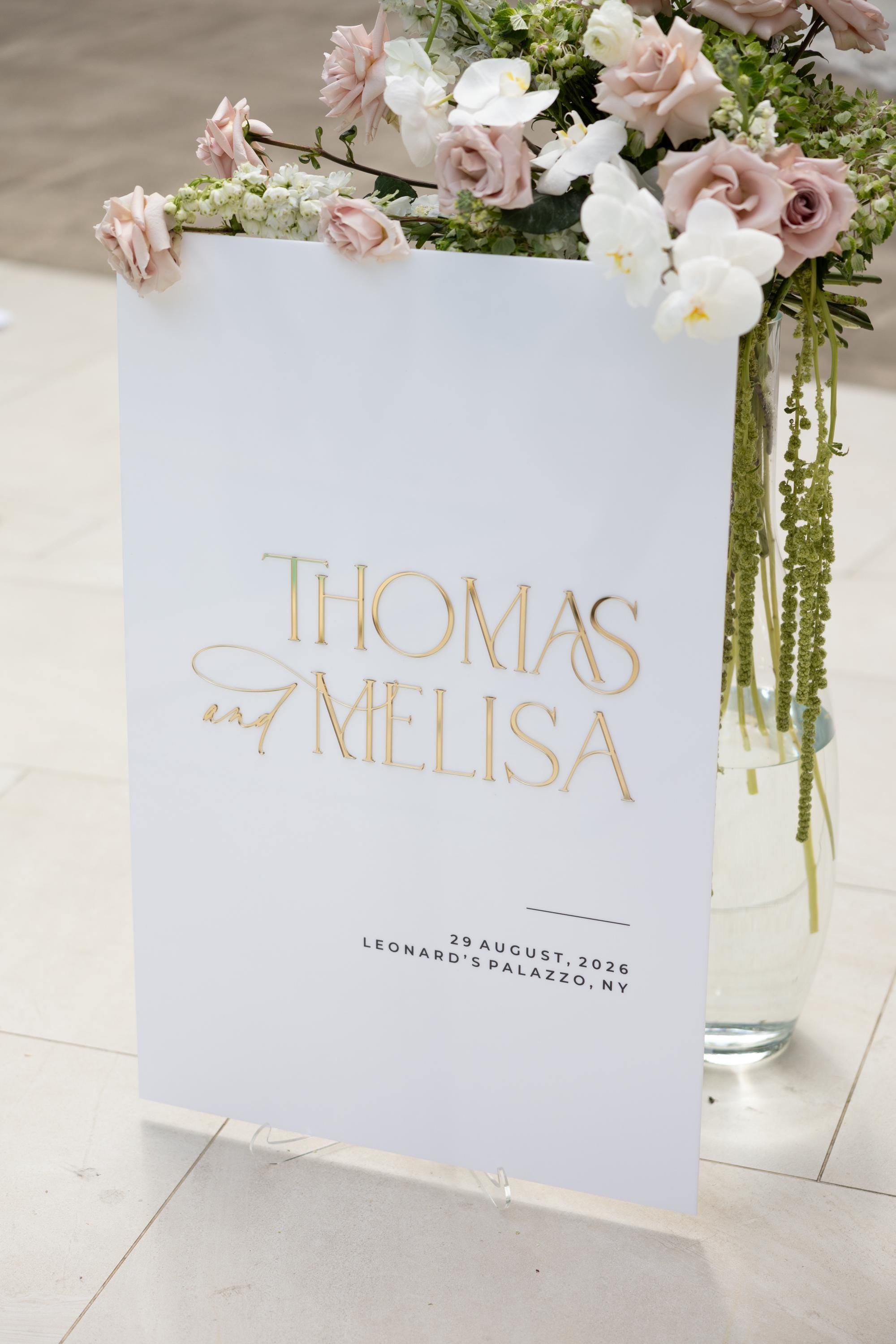 White and gold wedding welcome sign with personalized names and wedding details
