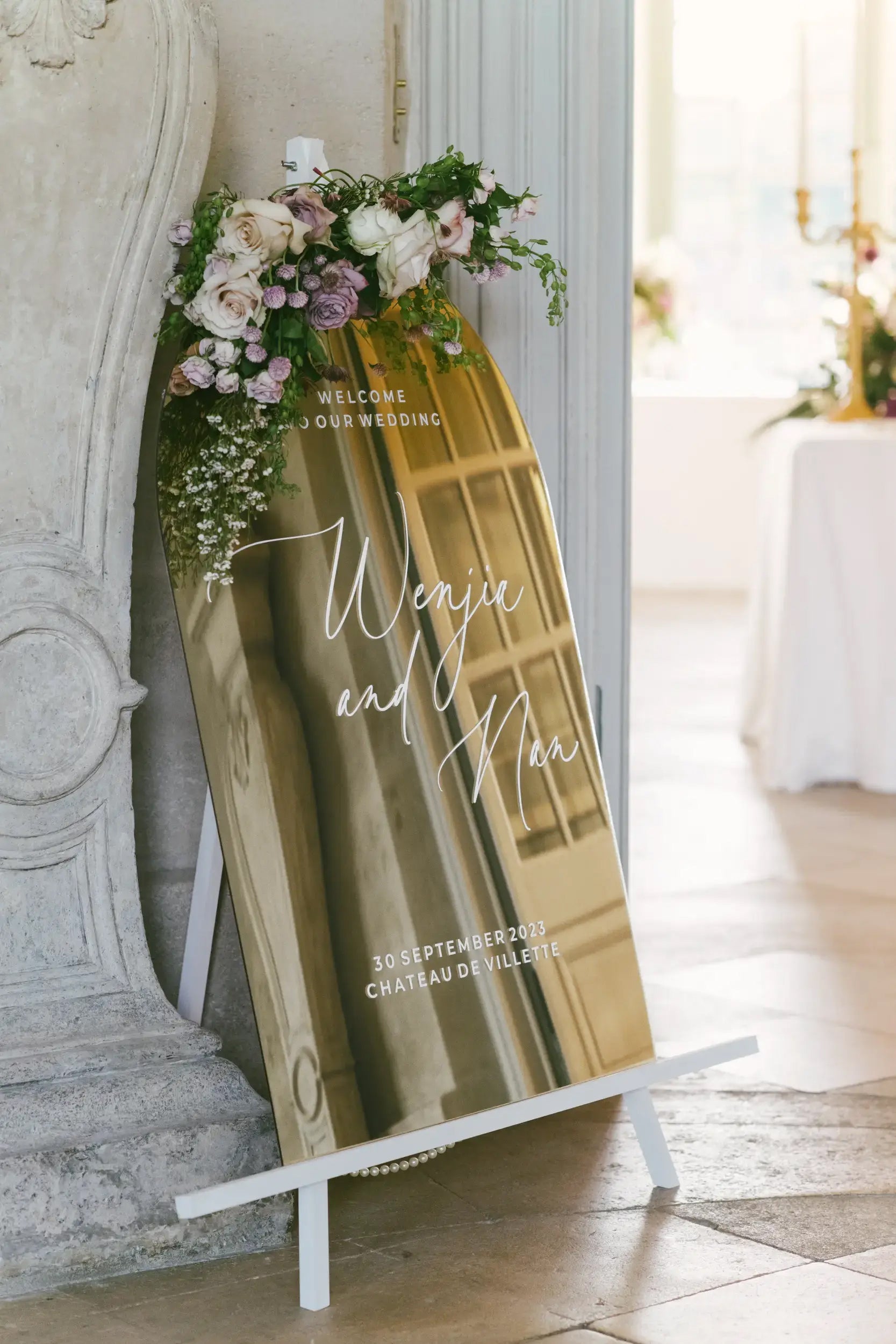 Close-up of elegant white calligraphy script on high-quality gold mirror acrylic.