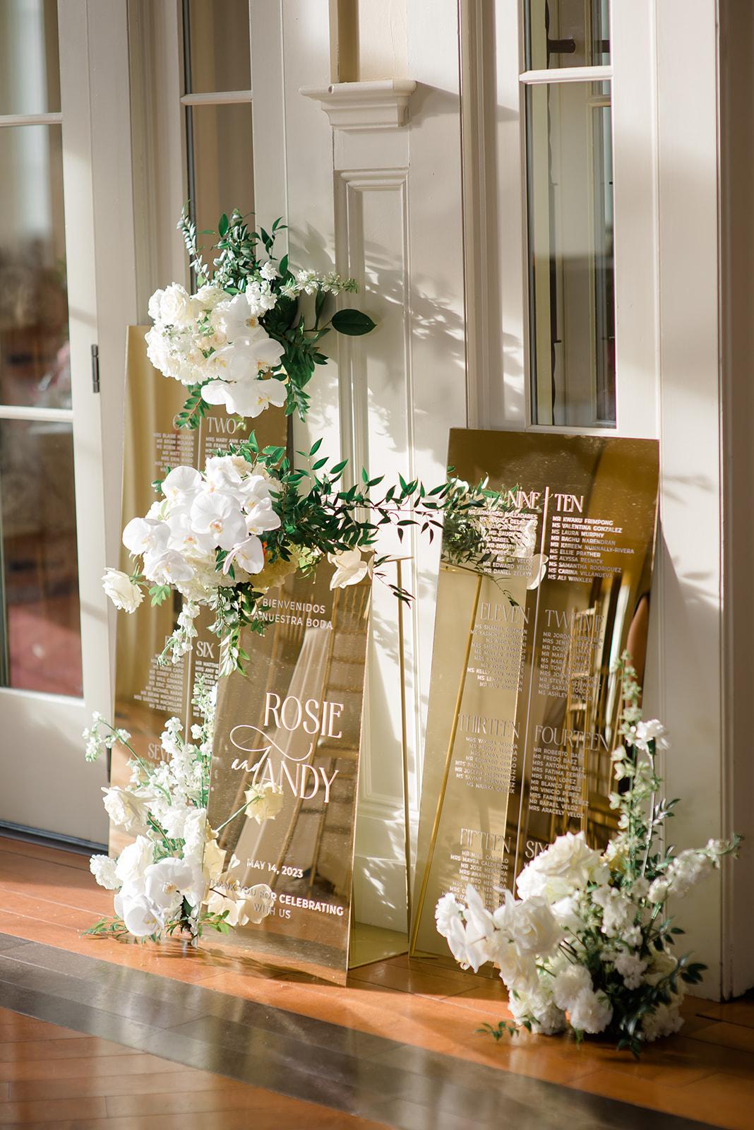 Gold mirror acrylic wedding seating chart and welcome sign displayed together for a wedding reception.