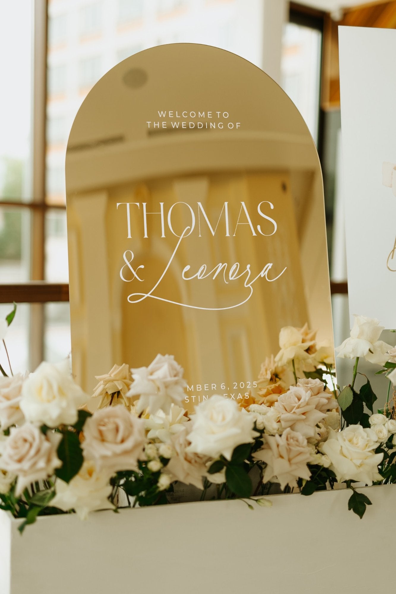 Contemporary wedding venue signage gold mirror with modern typography layout.