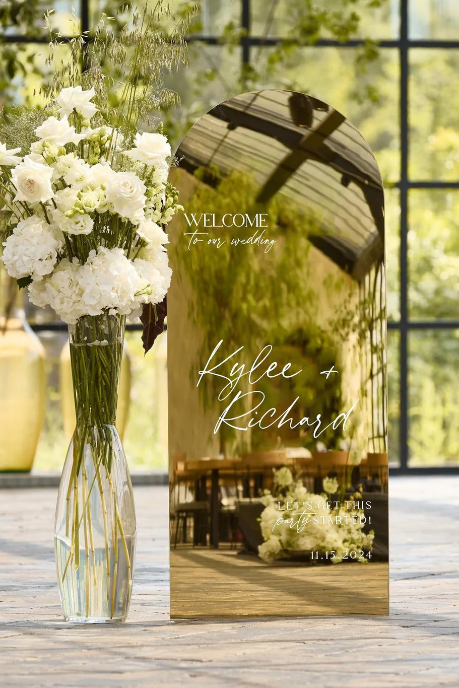 Polished gold mirror reception sign for contemporary weddings with minimalist white font.
