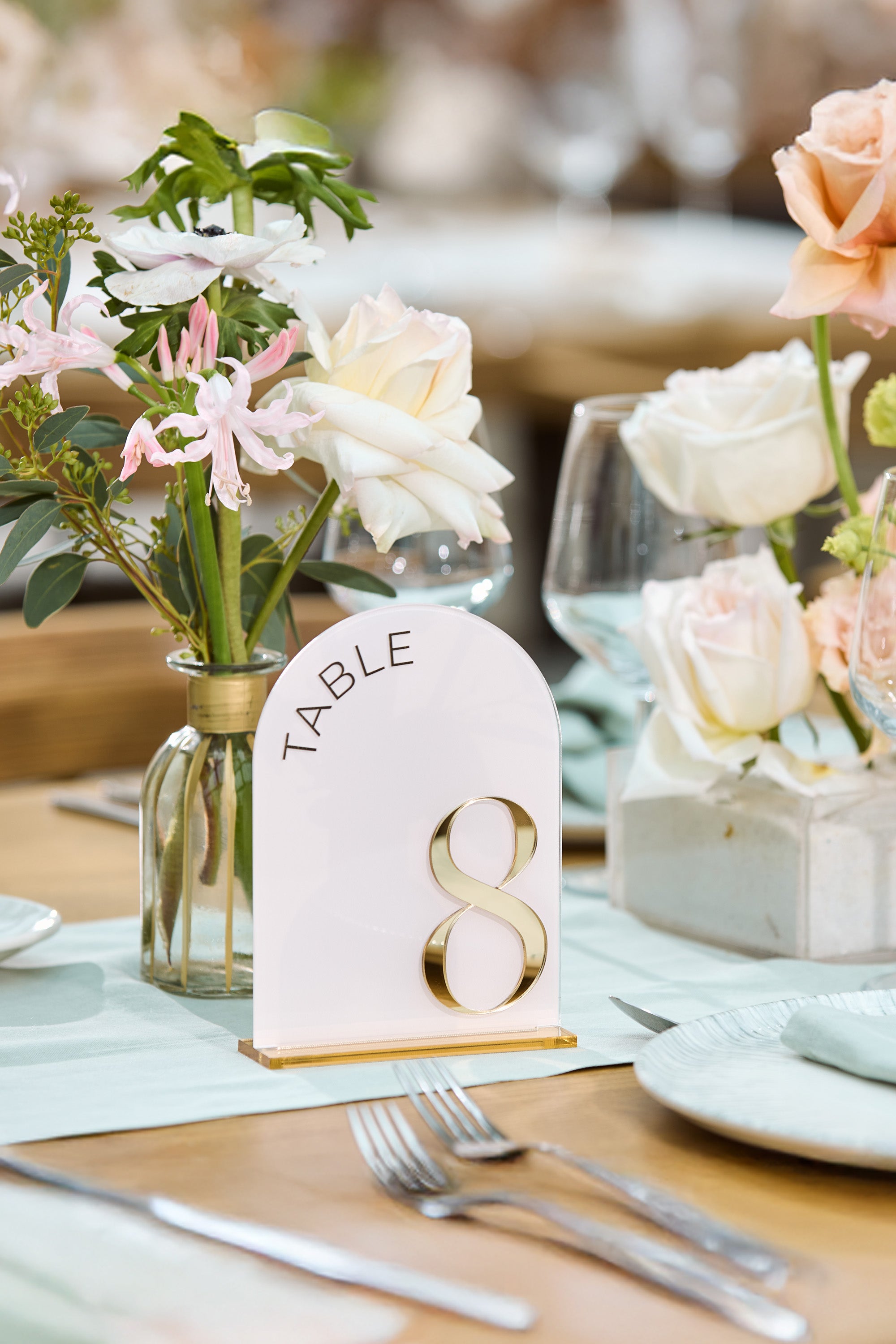 Romantic wedding table decor with pink and gold signage.