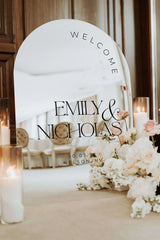 Arched silver mirror acrylic wedding welcome sign with personalized names displayed at ceremony entrance