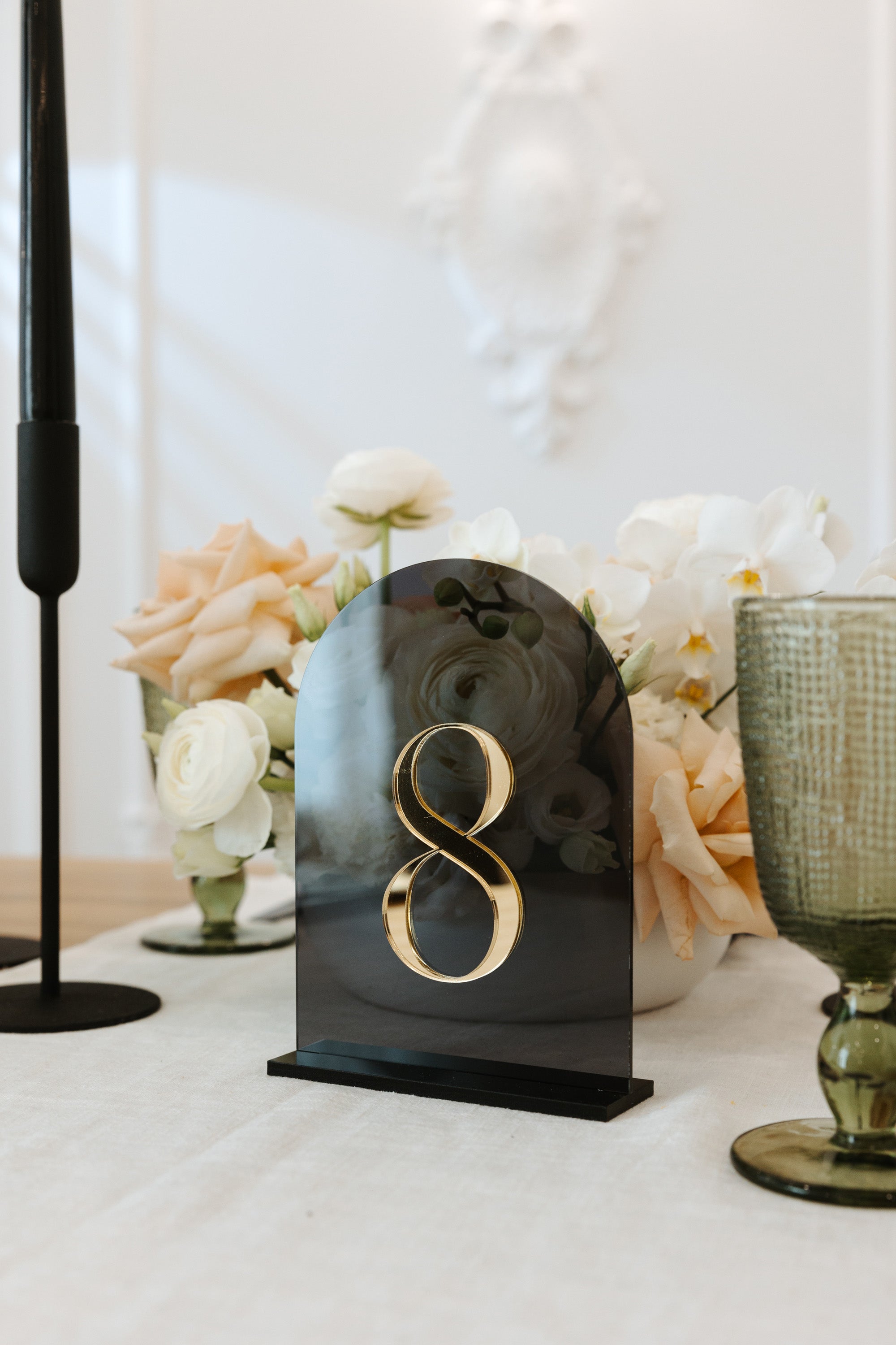 Smokey black acrylic wedding table numbers with arched shape.