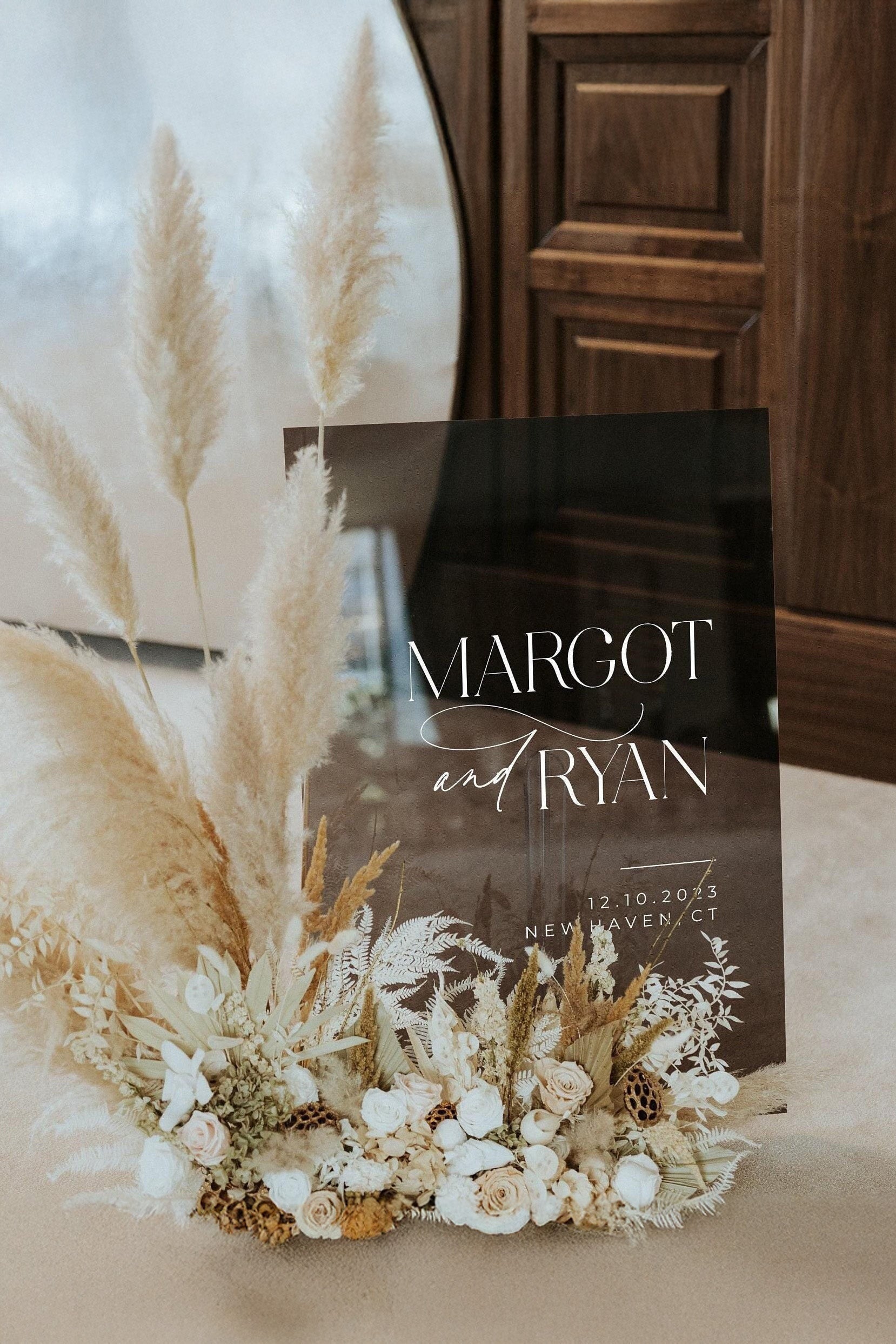 Smokey black acrylic wedding welcome sign with white text.